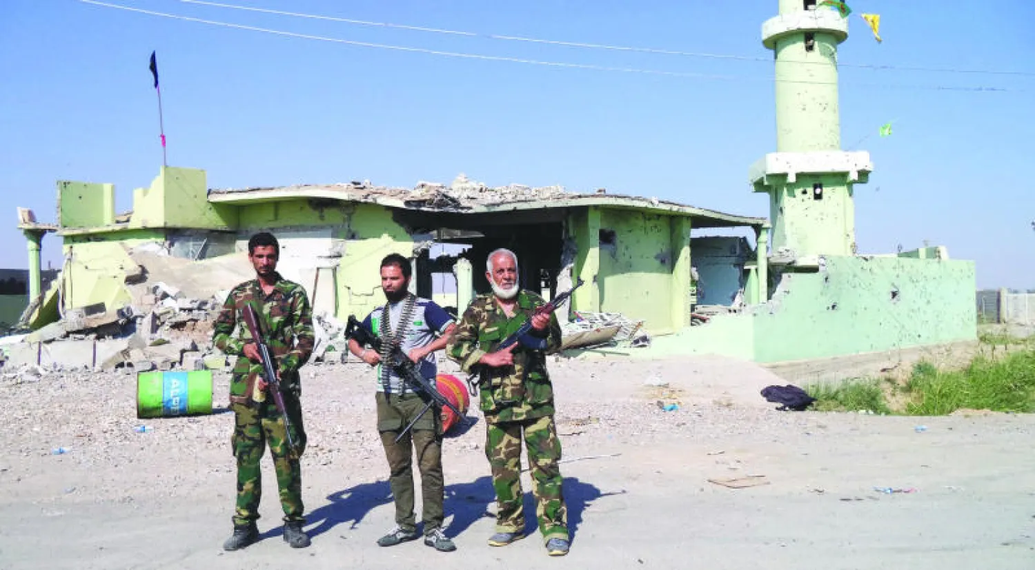 عناصر في «كتائب الخرساني» التي تساند القوات الحكومية في قرية شرق تكريت بعد طرد مسلحي «داعش» منها أمس (إ.ب.أ)