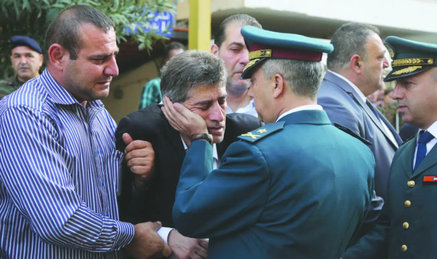 ضابط في الجيش اللبناني يواسي والد ملازم قتل في معارك طرابلس وذلك خلال حفل أقيم في بيروت أمس لـ«تكريم الشهداء» (رويترز)