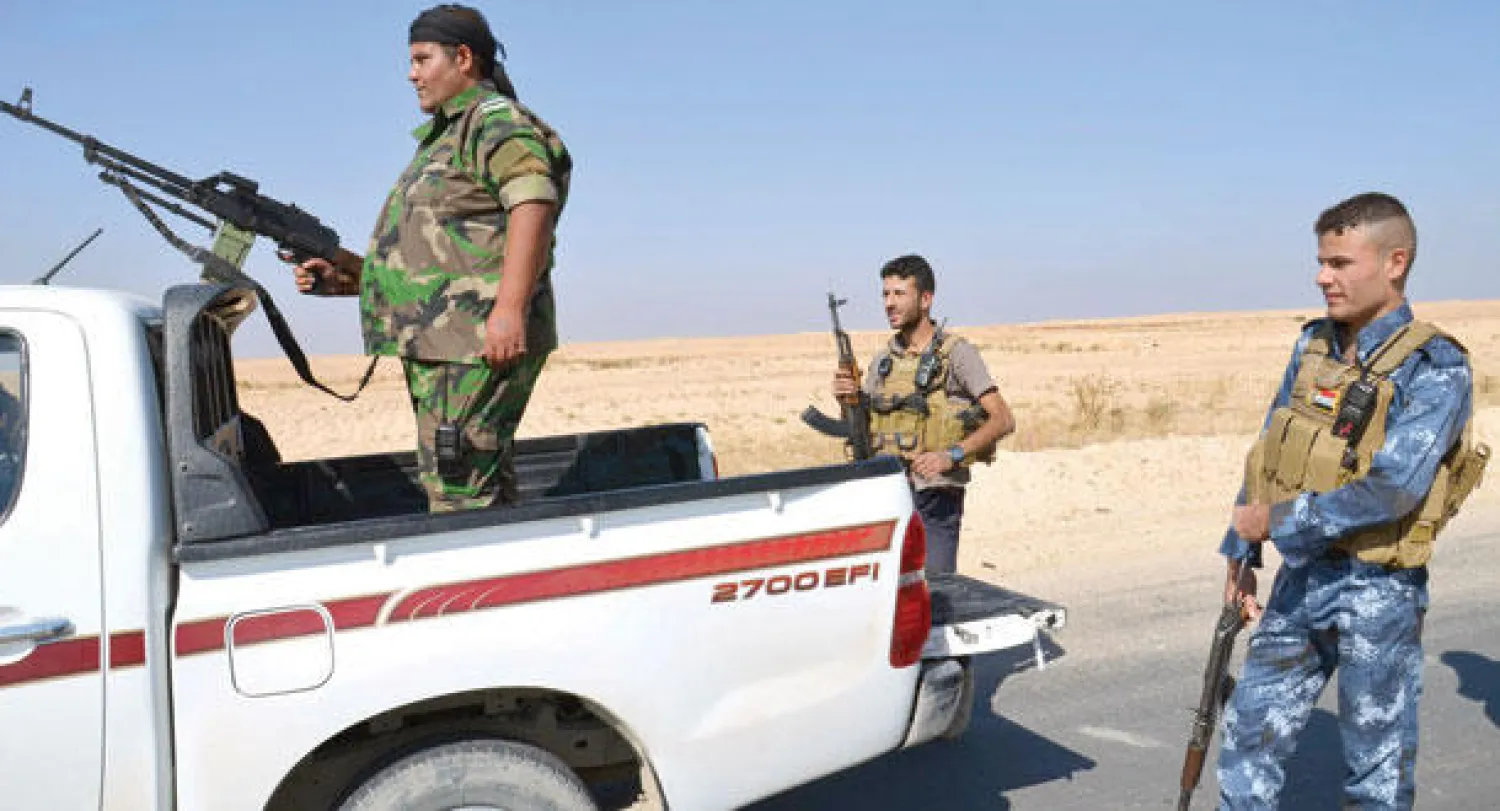 مسلحون من أبناء العشائر يحرسون منطقة قرب حديثة في مواجهة «داعش» (رويترز)