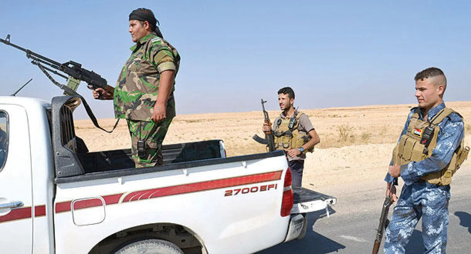 مسلحون من أبناء العشائر يحرسون منطقة قرب حديثة في مواجهة «داعش» (رويترز)