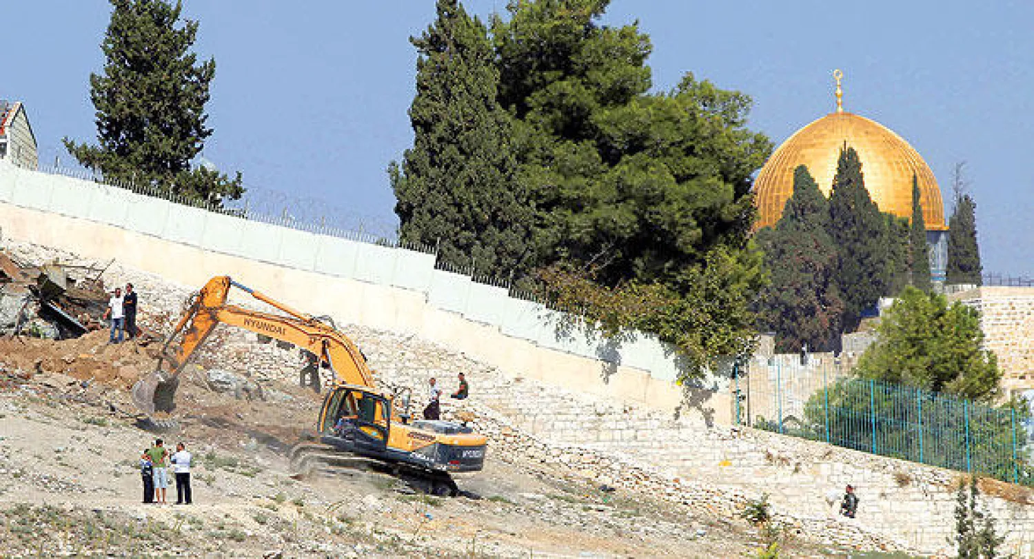 عمال إسرائيليون يقومون بهدم أكواخ فلسطينية في ضواحي بلدة سلوان أمس (أ.ف.ب)