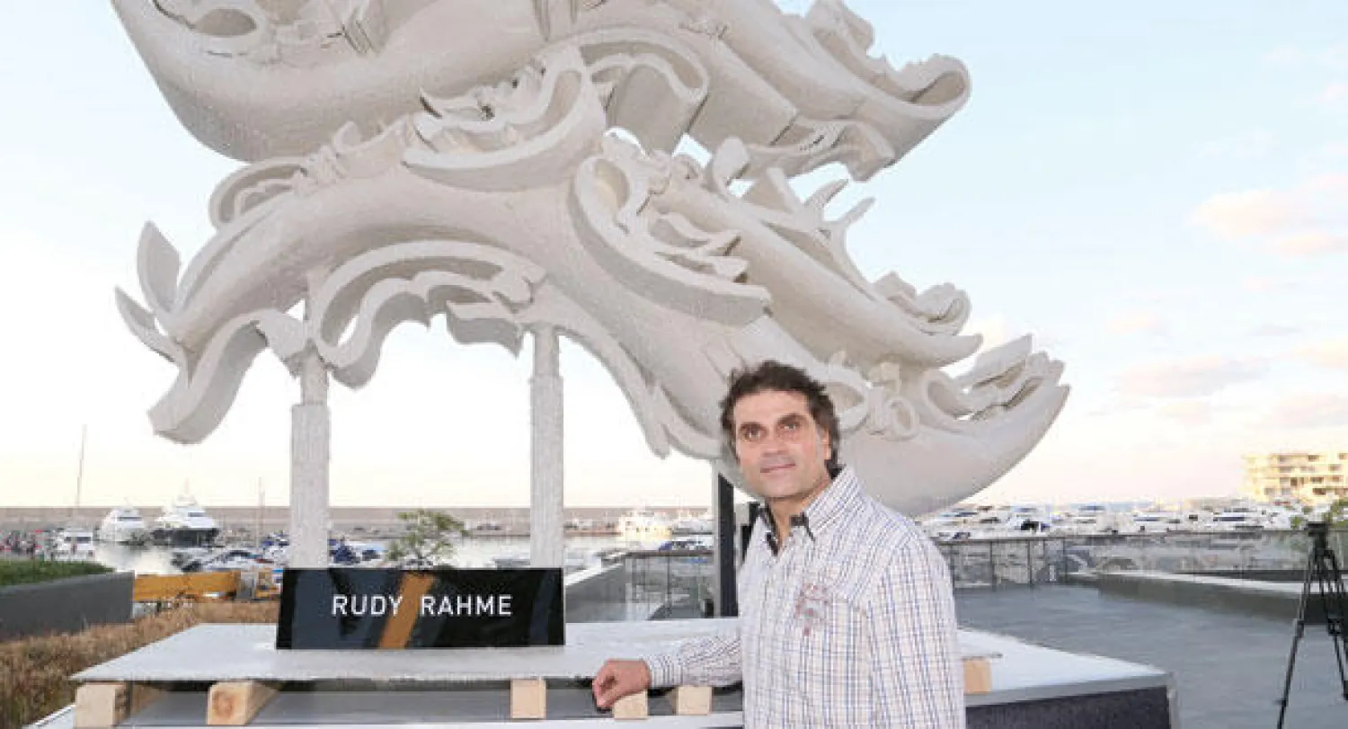 الفنان النحات رودي رحمة أمام مجسم الماراثون الذي سيشارك في فبراير المقبل في المزاد العلني