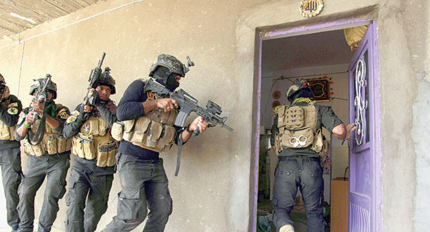 عناصر من القوات الخاصة في الجيش العراقي تمشط أمس بيوتا في بلدة جرف الصخر بعد تحريرها من تنظيم داعش قبل يومين (أ.ف.ب)