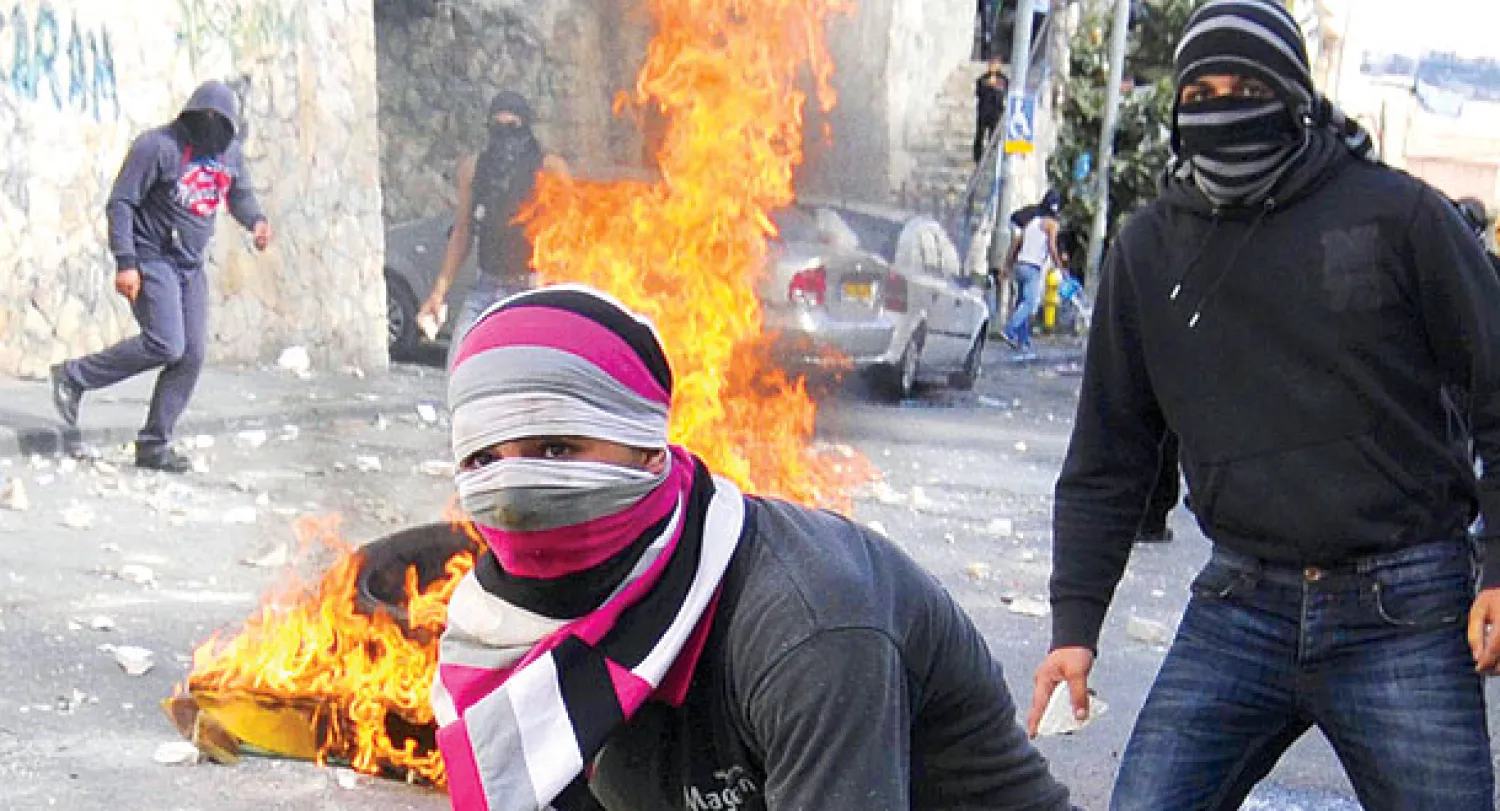  شاب فلسطيني يرمي زجاجة مولوتوف على قوات الأمن الإسرائيلي  خلال المواجهات الأخيرة التي أسفرت عن مقتل الشاب  معتز حجازي في القدس أمس (أ.ب) 