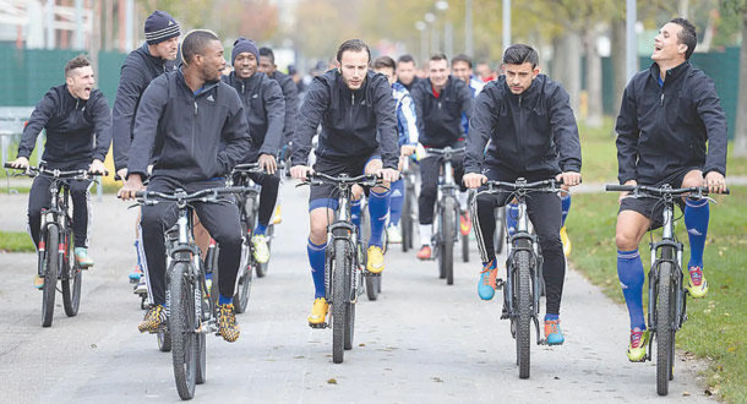 لاعبو بازل السويسري يتوجهون لملعب التدريب بالدراجات أمس (إ.ب.أ)