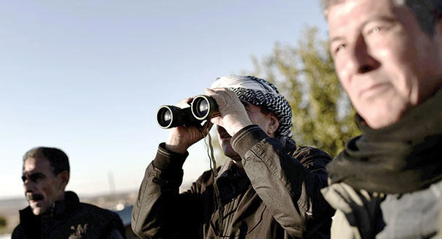 أكراد يتابعون المعارك خارج عين العرب/ كوباني (أ.ف.ب)