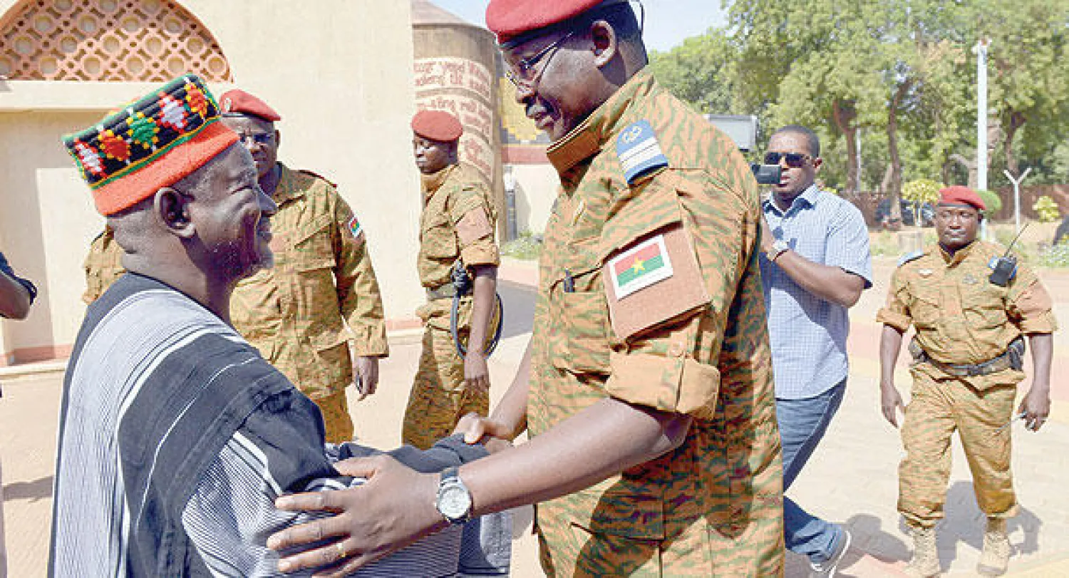 الكولونيل إسحق زيدا يسلم على شخص من قبيلة موسي في العاصمة واغادوغو أمس (أ.ف.ب)