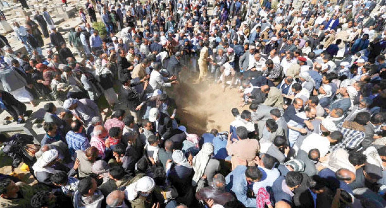 يمنيون يوارون جثمان المعارض اليمني محمد عبد الملك المتوكل الثرى أثناء تشييعه في صنعاء أمس (رويترز)