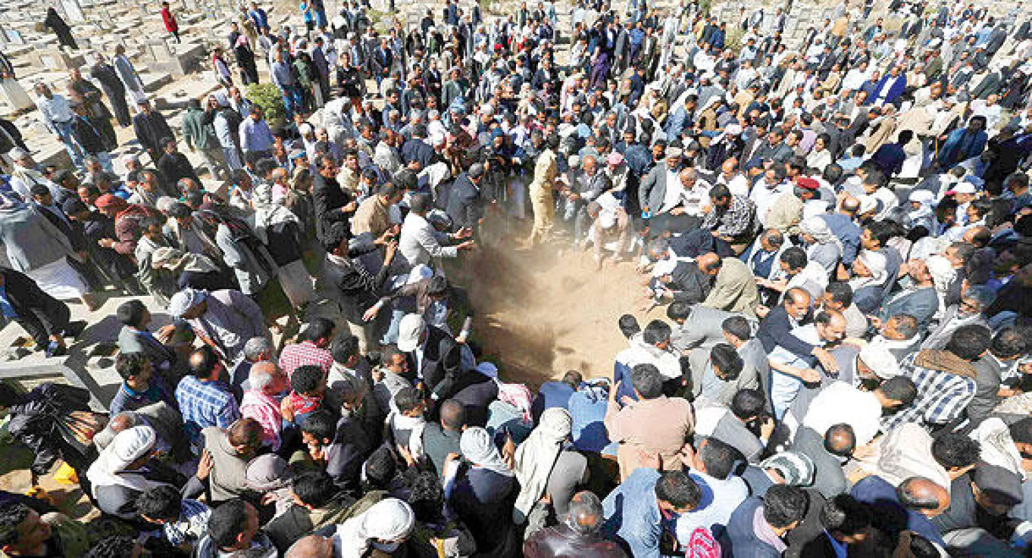 يمنيون يوارون جثمان المعارض اليمني محمد عبد الملك المتوكل الثرى أثناء تشييعه في صنعاء أمس (رويترز)