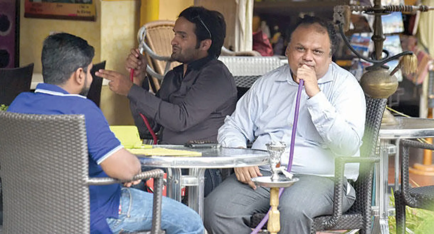 شبان يدخنون الشيشة في سنغافورة (أ.ف.ب)