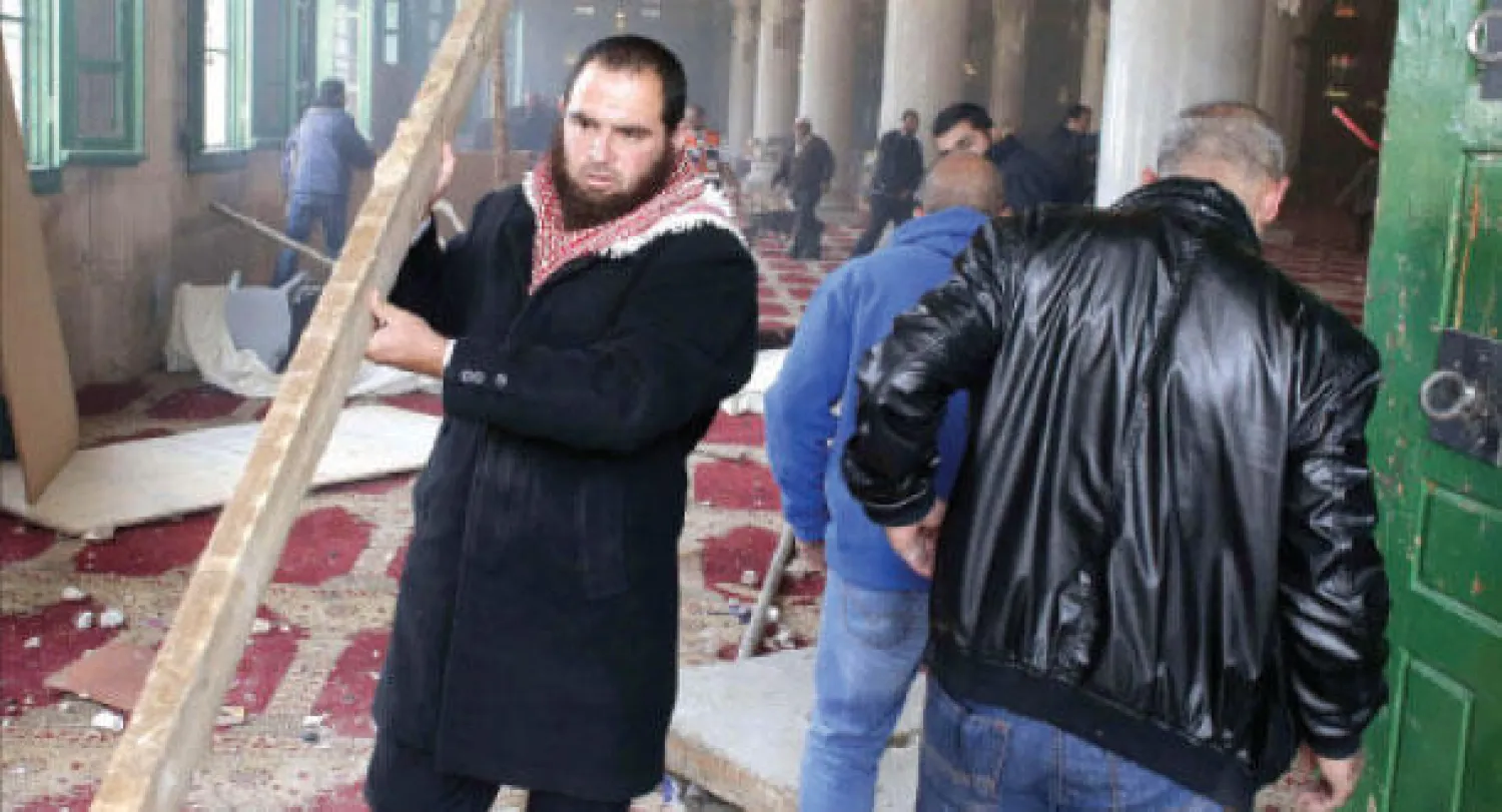 فلسطينيون يقومون بتنظيف المسجد الأقصى بعد المواجهات العنيفة التي وقعت بين قوات إسرائيلية وشبان فلسطينيين أمس (أ.ف.ب)