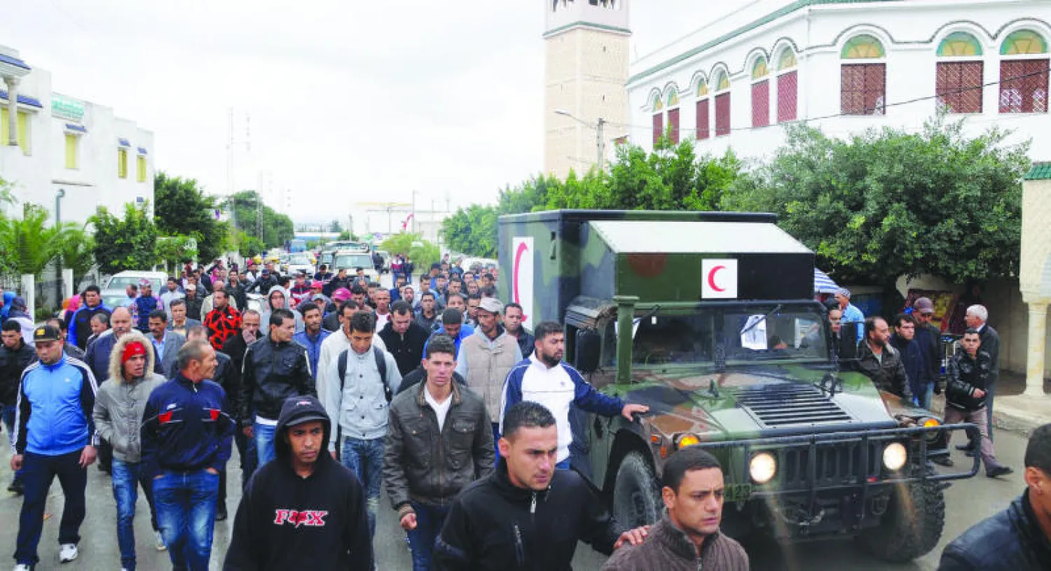 تونسيون يشيعون جنازة أحد الجنود الذين قتلوا في الهجوم الإرهابي الذي استهدف الحافلة العسكرية في مدينة الكاف أمس (إ.ب.أ)