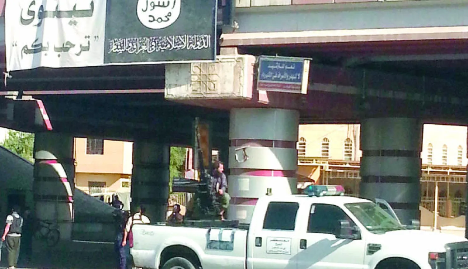 شعار داعش وسيارة تابعة لشرطتهم وسط مدينة الموصل (رويترز)