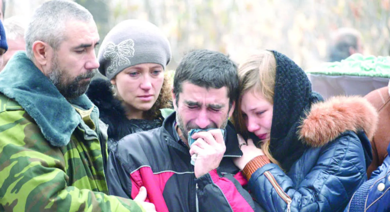 أقارب يبكون شابا وفتاة قتلا في قصف استهدف مدرستهما خلال جنازتهما في مدينة دونيتسك بشرق أوكرانيا أمس (أ.ب)