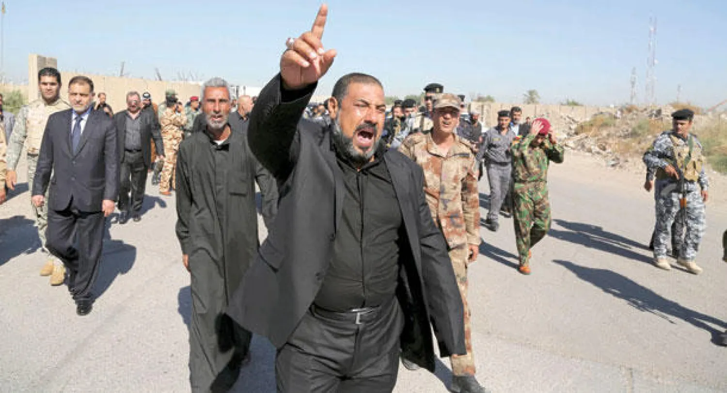 مشيع يردد أمس هتافات ضد «داعش» خلال جنازة ضابط الشرطة اللواء فيصل مالك الذي قتل في هجوم مساء أول من أمس (أ.ب)