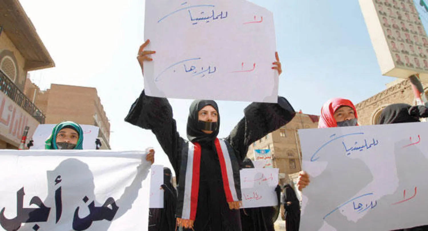 يمنية ترفع لافتة كتب عليها «لا للميليشيات.. لا للإرهاب» خلال مظاهرة، بصنعاء، أمس مناوئة لسيطرة الميليشيات الحوثية على كثير من أنحاء اليمن (أ.ف.ب)