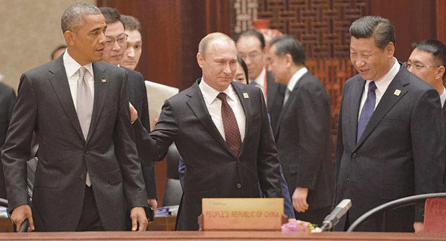 بوتين يتوسط أوباما وتشي خلال «قمة آبيك» ببكين أمس (أ.ب)