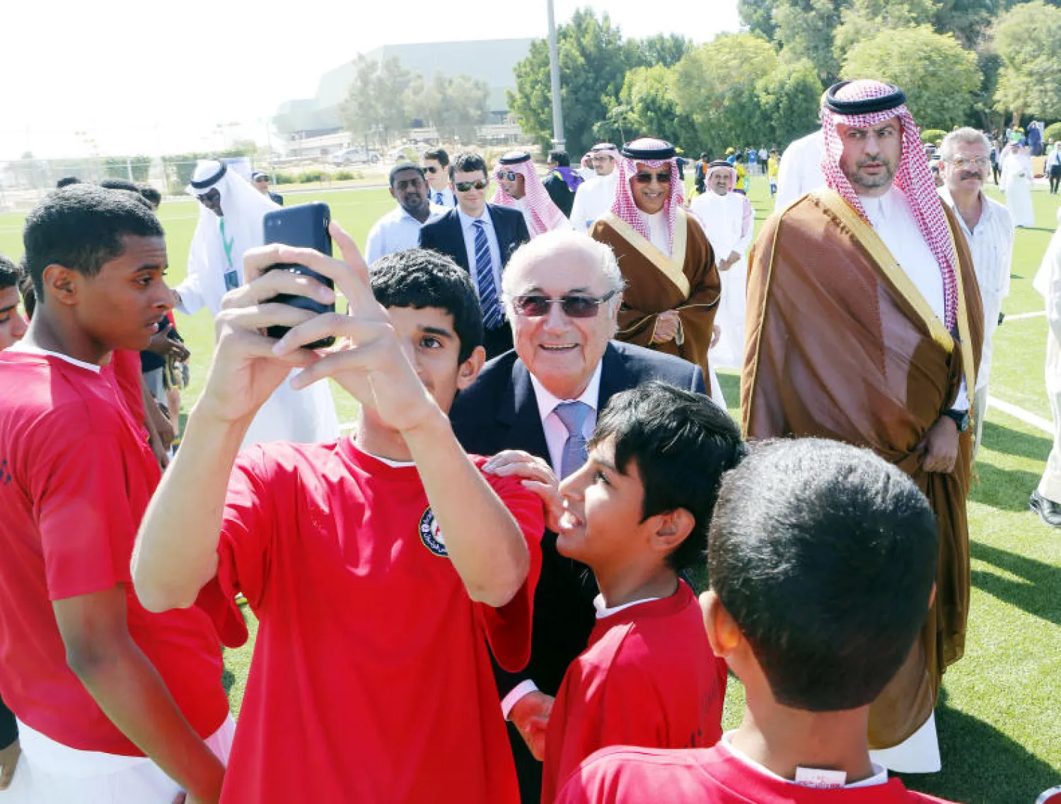 بلاتر يلتقط صورة سيلفي مع أطفال سعوديين كانوا في استقباله لدى افتتاحه ملعبا جديدا في الرياض