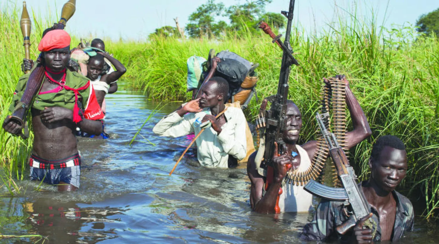 مسلحون يقومون بحماية مدنيين في جنوب السودان (أ.ب)