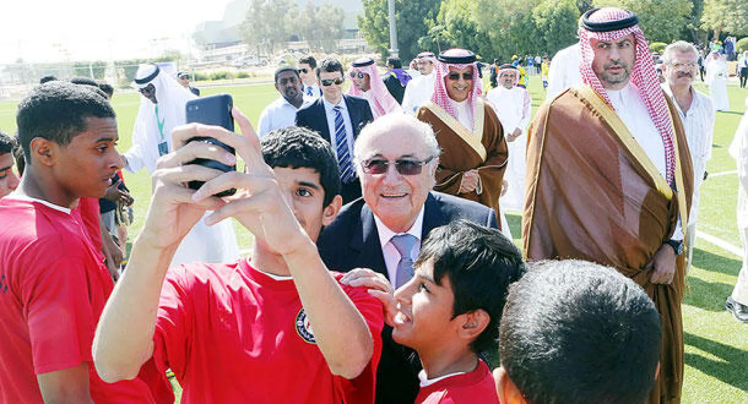 بلاتر يلتقط صورة سيلفي مع أطفال سعوديين كانوا في استقباله لدى افتتاحه ملعبا جديدا في الرياض