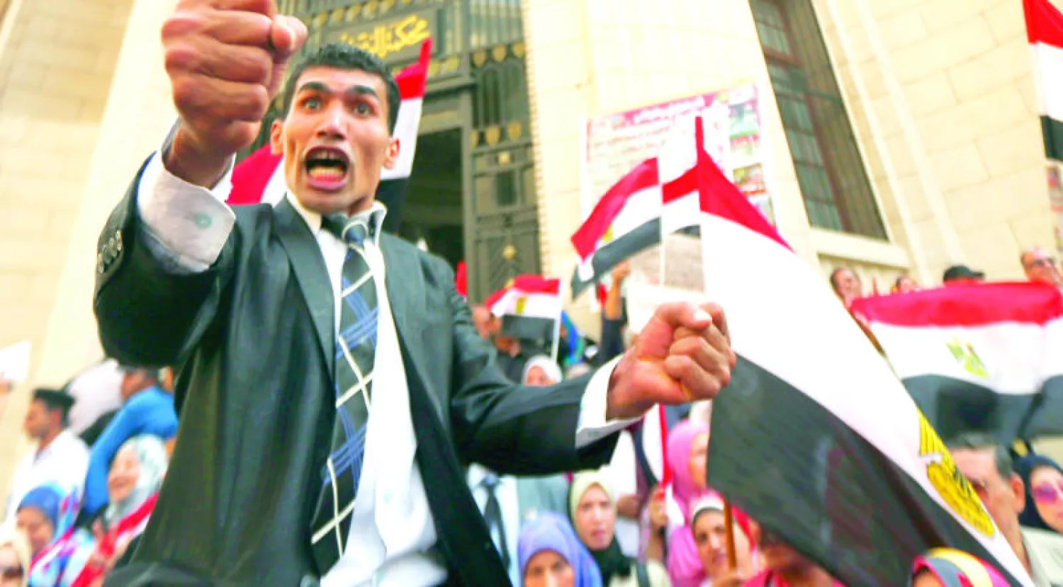 متظاهر مصري يندد بعنف الإخوان المسلمين والجماعات المسلحة من خلال حملة تسعى لجمع مليون توقيع للمطالبة بمحاكمة نشطاء المعارضة الذين يقيمون في الخارج (رويترز)