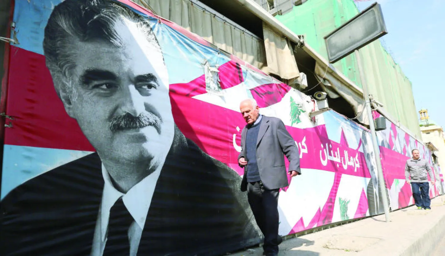 لبناني يمر بجانب ملصق للراحل رفيق الحريري في بيروت (أ.ف.ب)