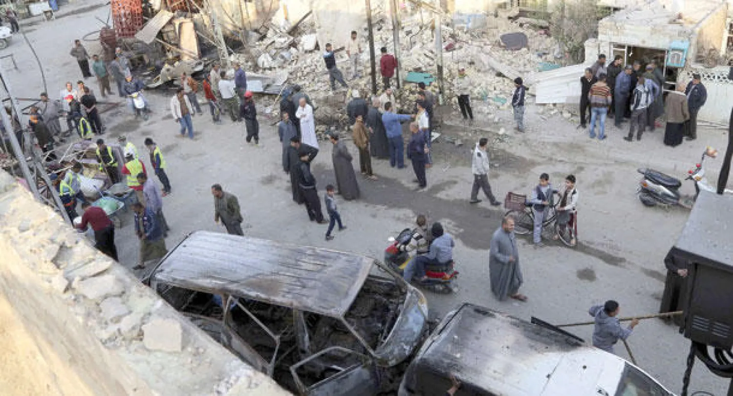 عراقيون يعاينون موقع انفجار وقع أول من أمس في منطقة الكريعات (أ.ب)