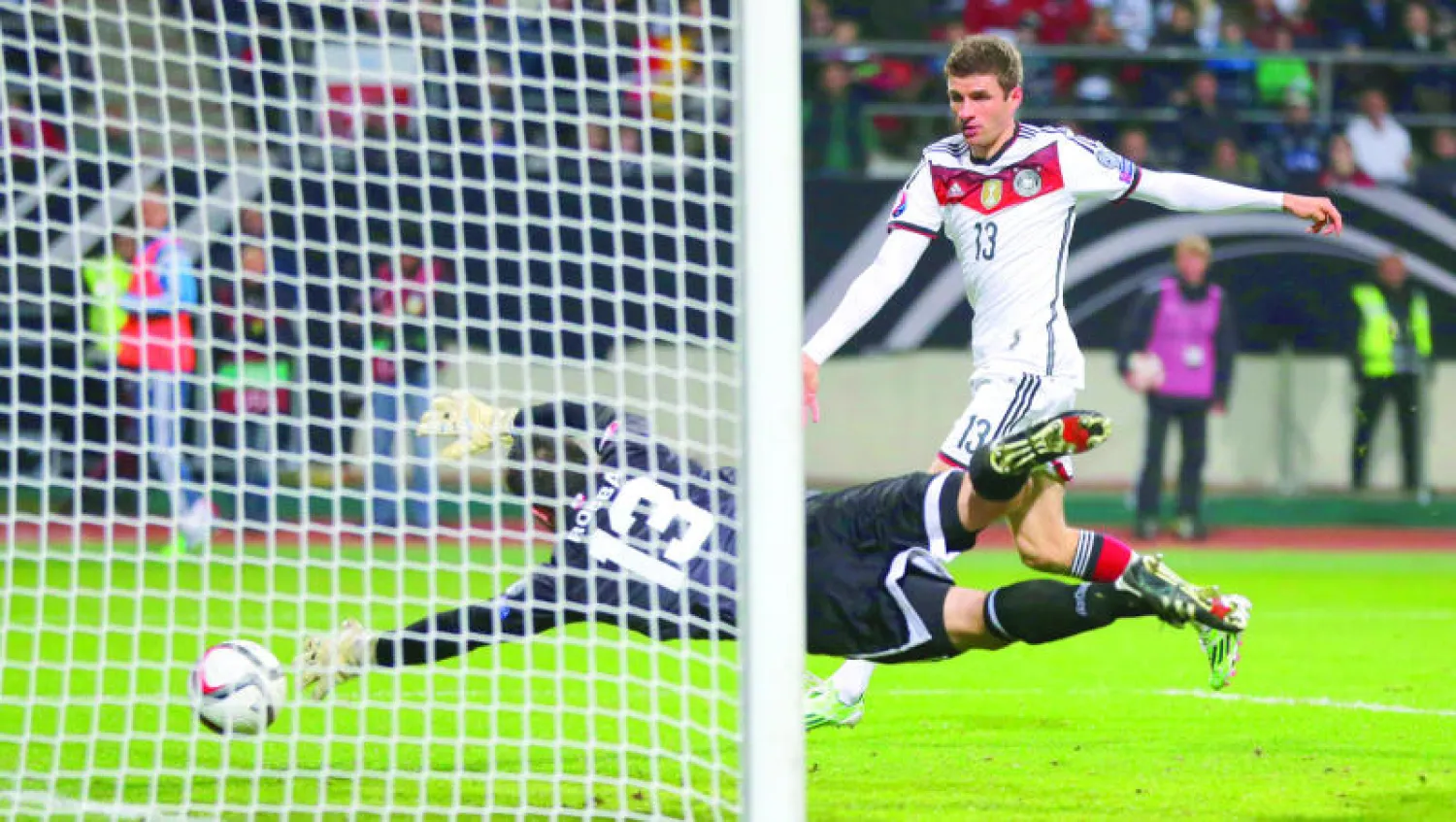 مولر نجم ألمانيا يسدد في شباك حارس جبل طارق ليحرز هدفه الثاني من الرباعية التي فاز بها منتخبه (أ.ب)