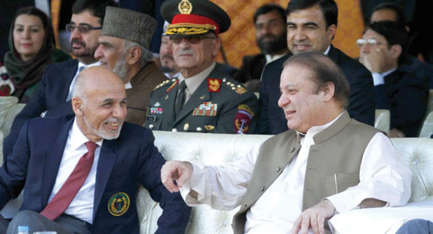 شريف (يمين) وغني أثناء مشاهدتهما مباراة ودية في الكريكيت بين فريقي بلديهما على هامش زيارة الرئيس الأفغاني إلى إسلام آباد أمس (إ.ب.أ)