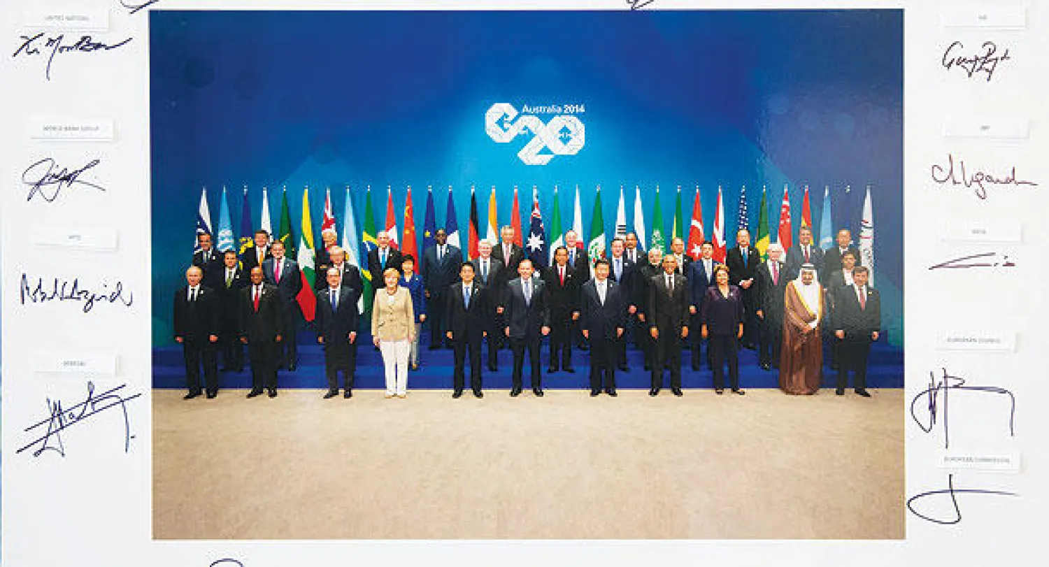 تواقيع قادة دول العشرين حول الصورة الرسمية للقادة في ختام قمة بريزبن (إ.ب.أ)