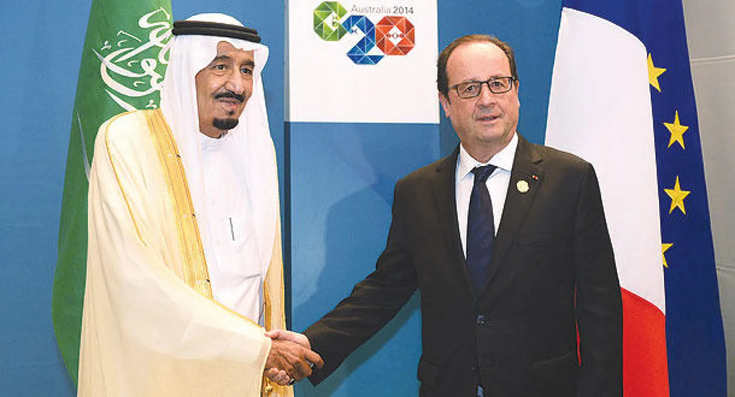 الأمير سلمان يصافح الرئيس الفرنسي على هامش قمة الـ 20 أمس (أ.ف.ب)