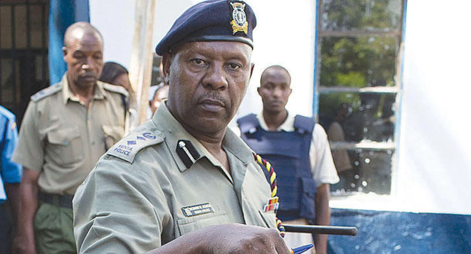 ضابط شرطة يعرض قنبلة عثر عليها أثناء مداهمة مسجد يرتاده متشددون في مومباسا أمس (أ.ف.ب)