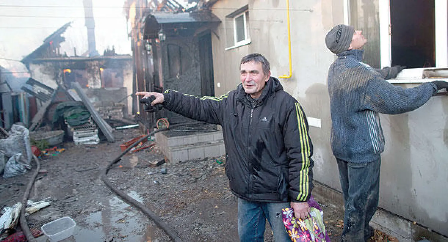 رجل يتحدث بحسرة أمام منزله الذي استهدفه القصف في منطقة قريبة من مطار دونيتسك أمس (أ.ف.ب)