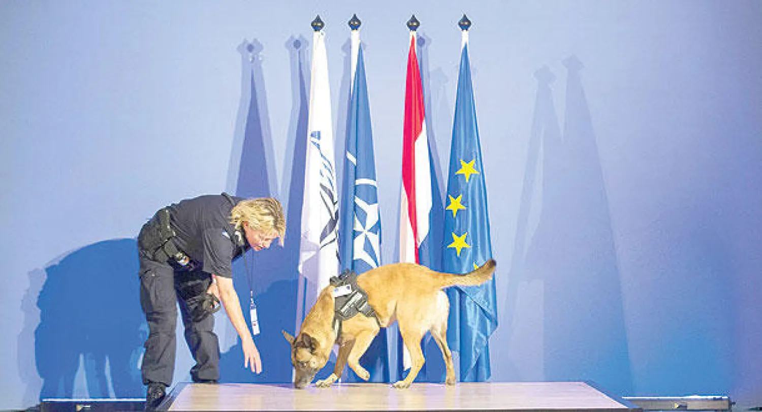 ضابطة شرطة هولندية تستعين بكلب مدرب أمس لضمان أمن جلسات الجمعية البرلمانية  لحلف شمال الأطلسي المنعقدة حالياً في لاهاي التي تبحث خصوصا الأزمة الأوكرانية (إ.ب.أ)