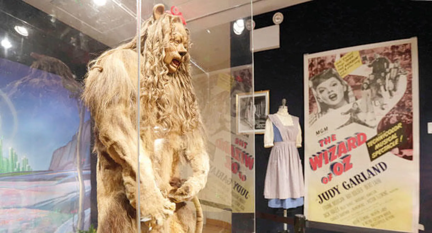 بدلة الأسد التي لبسها لاهر في فيلم {عبقري أوز{ مع ملصق الفيلم في مزاد بونهامز (أ.ب)