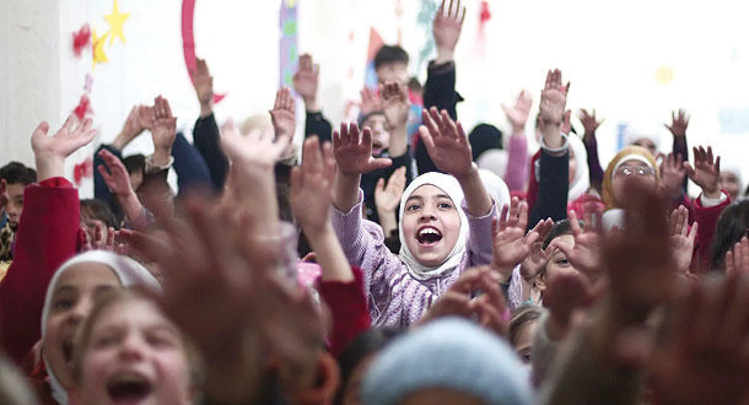 أطفال من بلدة دوما بريف دمشق التي يحاصرها النظام منذ أكثر من سنة يشاركون  في فعالية دعم نفسي للهلال الأحمر العربي (أ.ف.ب)