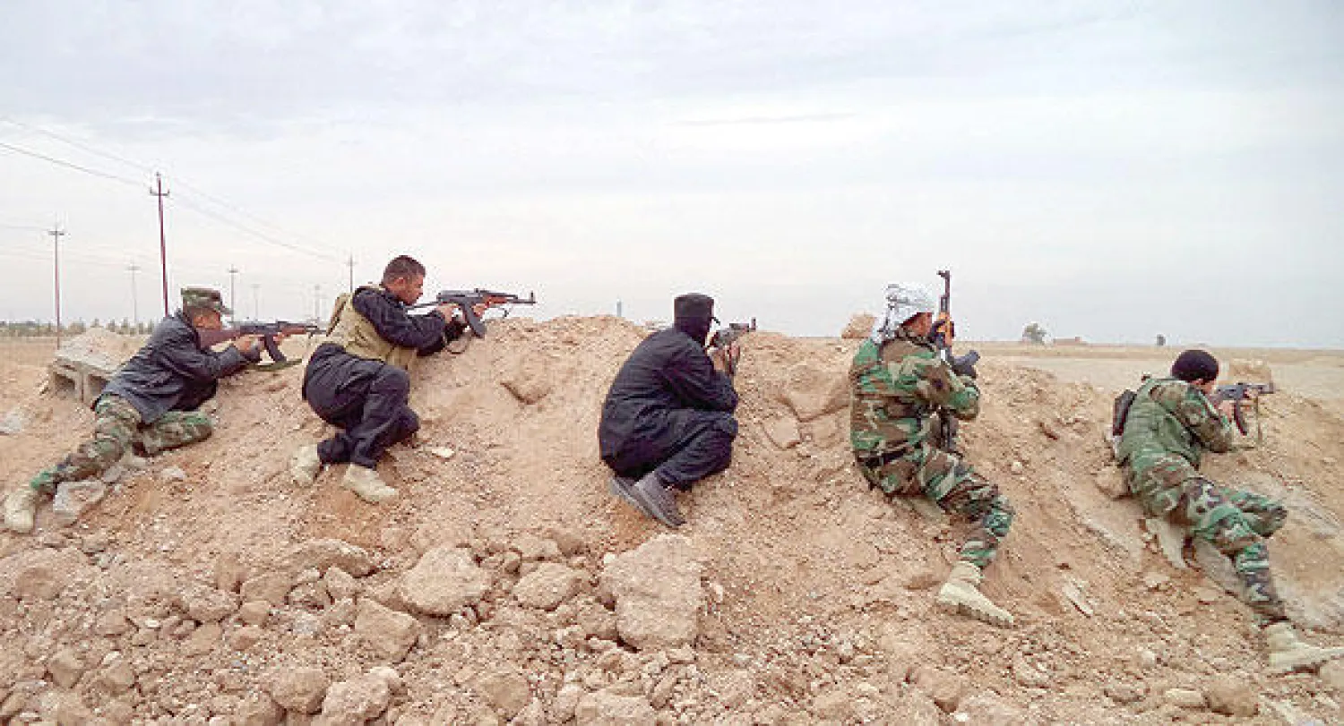 جنود عراقيون ومعهم بعض متطوعي «الحشد الشعبي» يتموضعون قرب مدينة آمرلي شمال العراق أمس (إ.ب.أ)