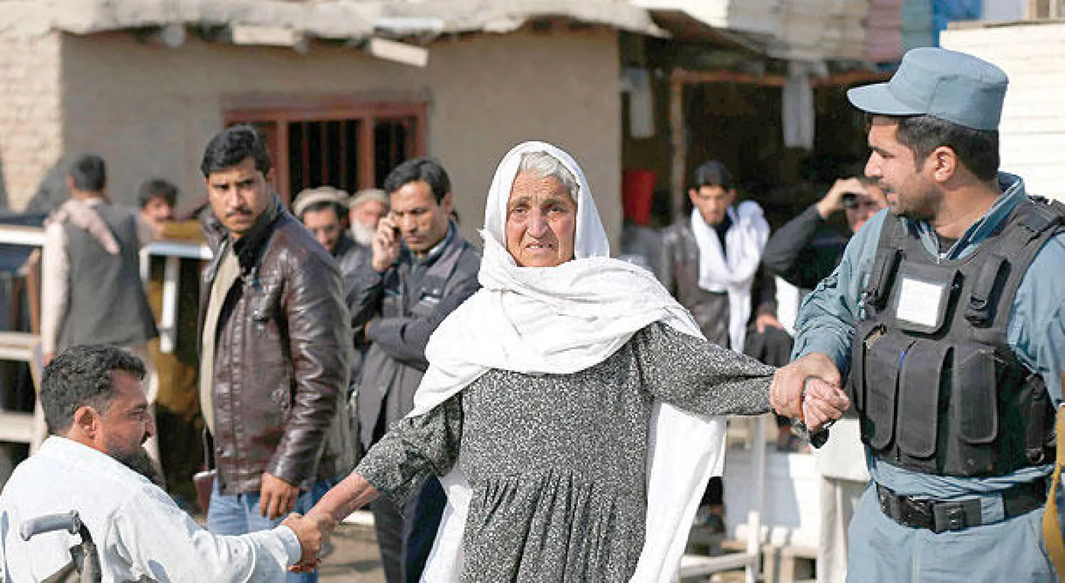 سيدة مسنة يبدو عليها القلق لدى البحث عن أقارب لها في موقع الهجوم الانتحاري بكابل أمس (رويترز)