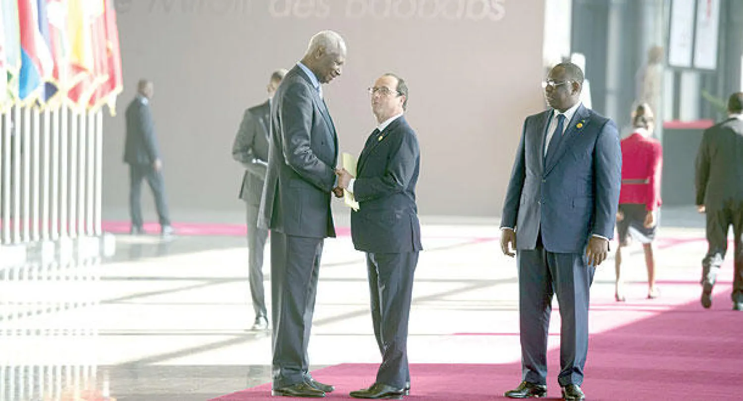 الرئيس هولاند (وسط) يتحدث إلى الأمين العام لمنظمة الفرنكوفونية عبدو ضيوف بينما يقف إلى جانبهما الرئيس سال في دكار أمس (أ.ف.ب)