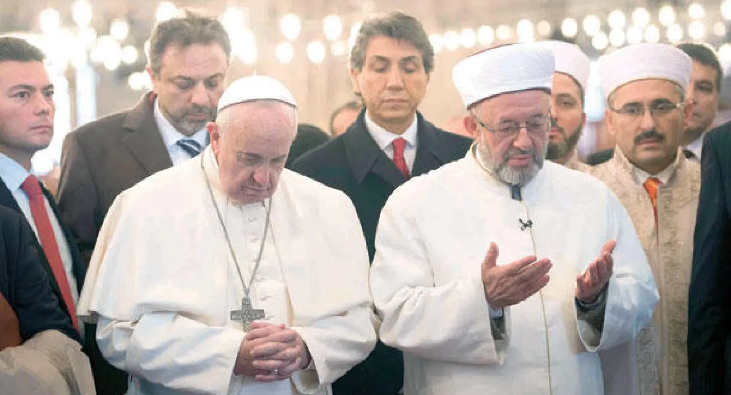 البابا فرنسيس  بجوار مفتي إسطنبول رحمي ياران يصليان في الجامع الأزرق ويتجهان إلى الكعبة المشرفة بالدعاء في إسطنبول أمس (رويترز)