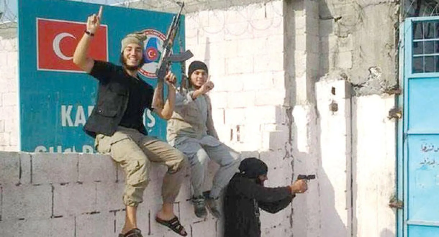 مقاتلون من «داعش» لدى عبورهم محيط بوابة مرشد بينار من الجانب التركي أمس («الشرق الأوسط»)