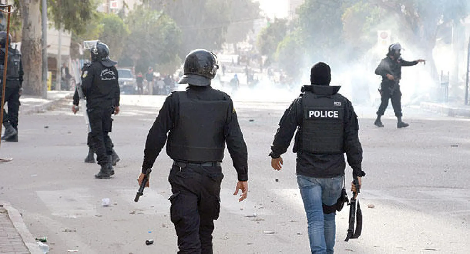 عناصر من شرطة مكافحة الشغب يفرقون مظاهرة احتجاجا على نتائج الدورة الأولى من الإنتخابات الرئاسية في تونس العاصمة (غيتي)