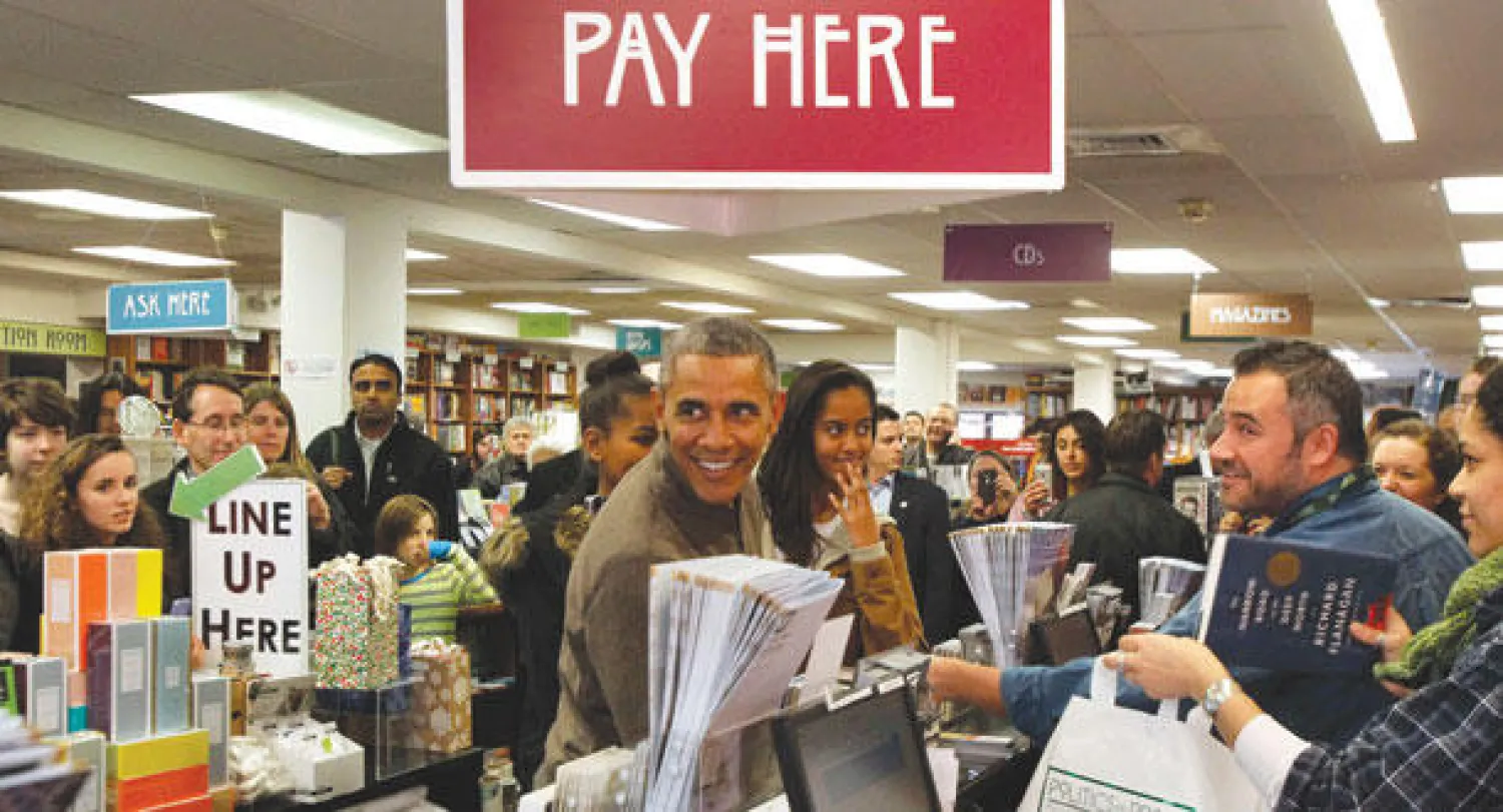 باراك أوباما وابنتاه ساشا وماليا داخل متجر في واشنطن (رويترز)