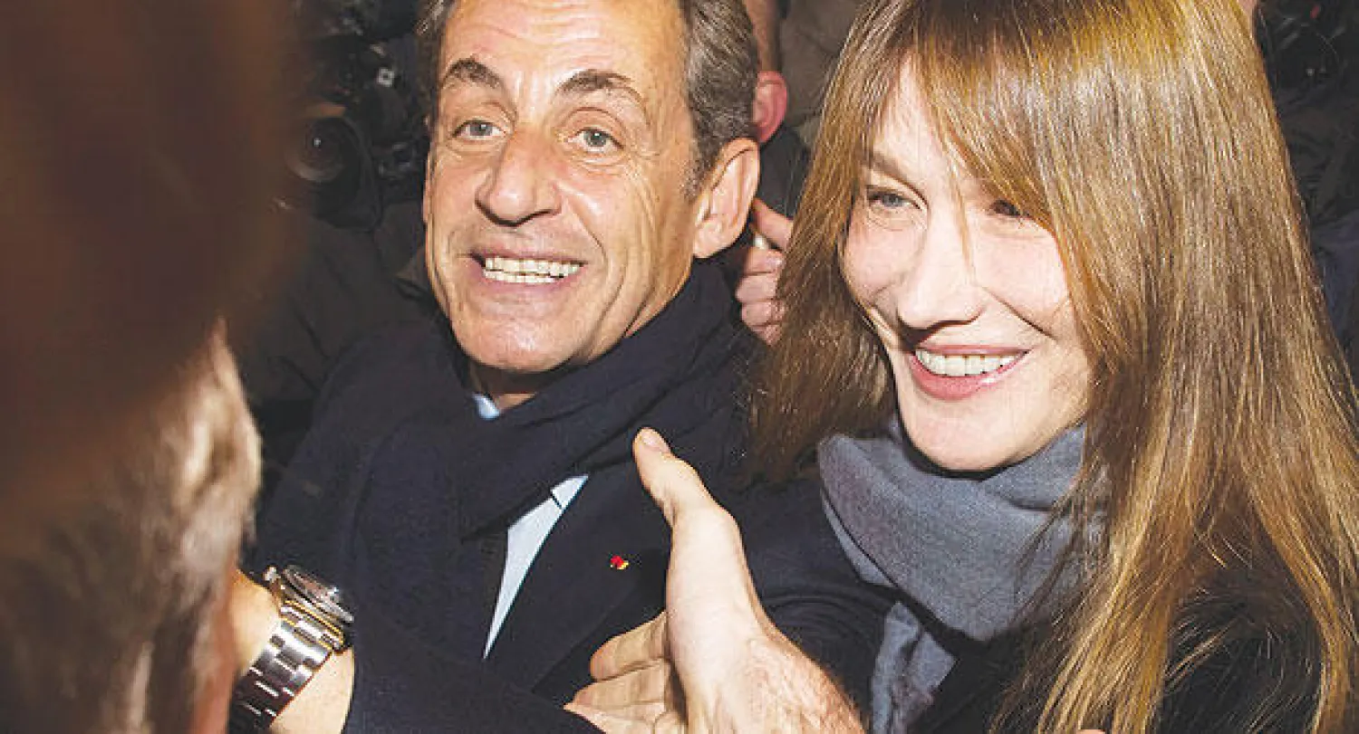 نيكولا ساركوزي وزوجته كارلا بروني بعد الإعلان عن فوزه برئاسة حزبه مساء أول من أمس (إ.ب.أ)