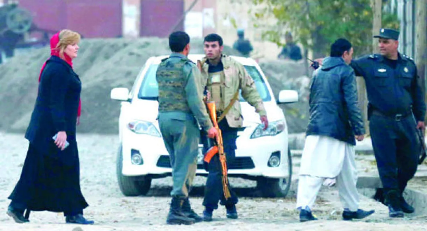 مواطنة غربية أمام مجمع الإغاثة والمساعدات الدولية في الحي الدبلوماسي بوزير أكبر خان عقب الهجوم الانتحاري في العاصمة كابل أمس (رويترز) 