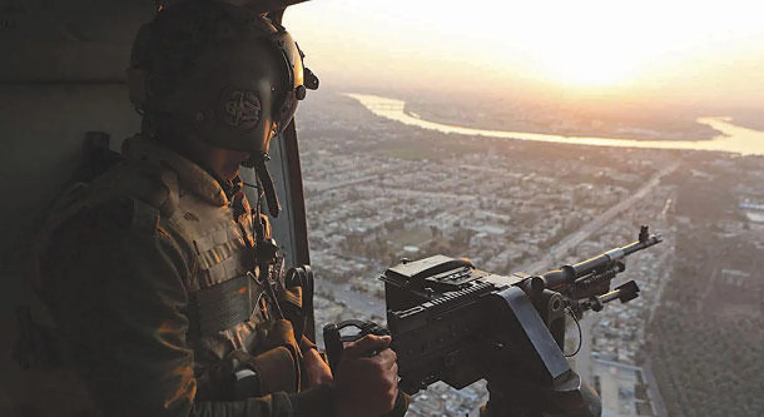 جندي عراقي يؤمن منطقة من على متن مروحية يستقلها وزير الدفاع خالد العبيدي خلال زيارته إلى ديالى أمس (أ.ب)