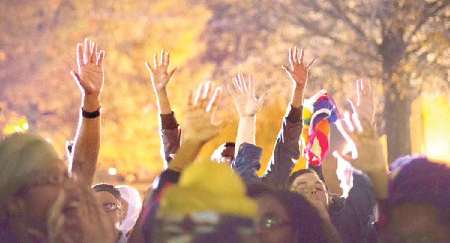 متظاهرون يرفعون أياديهم خارج كنيسة في أتلانتا أول من أمس تزامنا مع تجمع قاده وزير العدل إريك هولدر لتهدئة النفوس بعد احتجاجات فيرغسون الأخيرة (أ.ب)