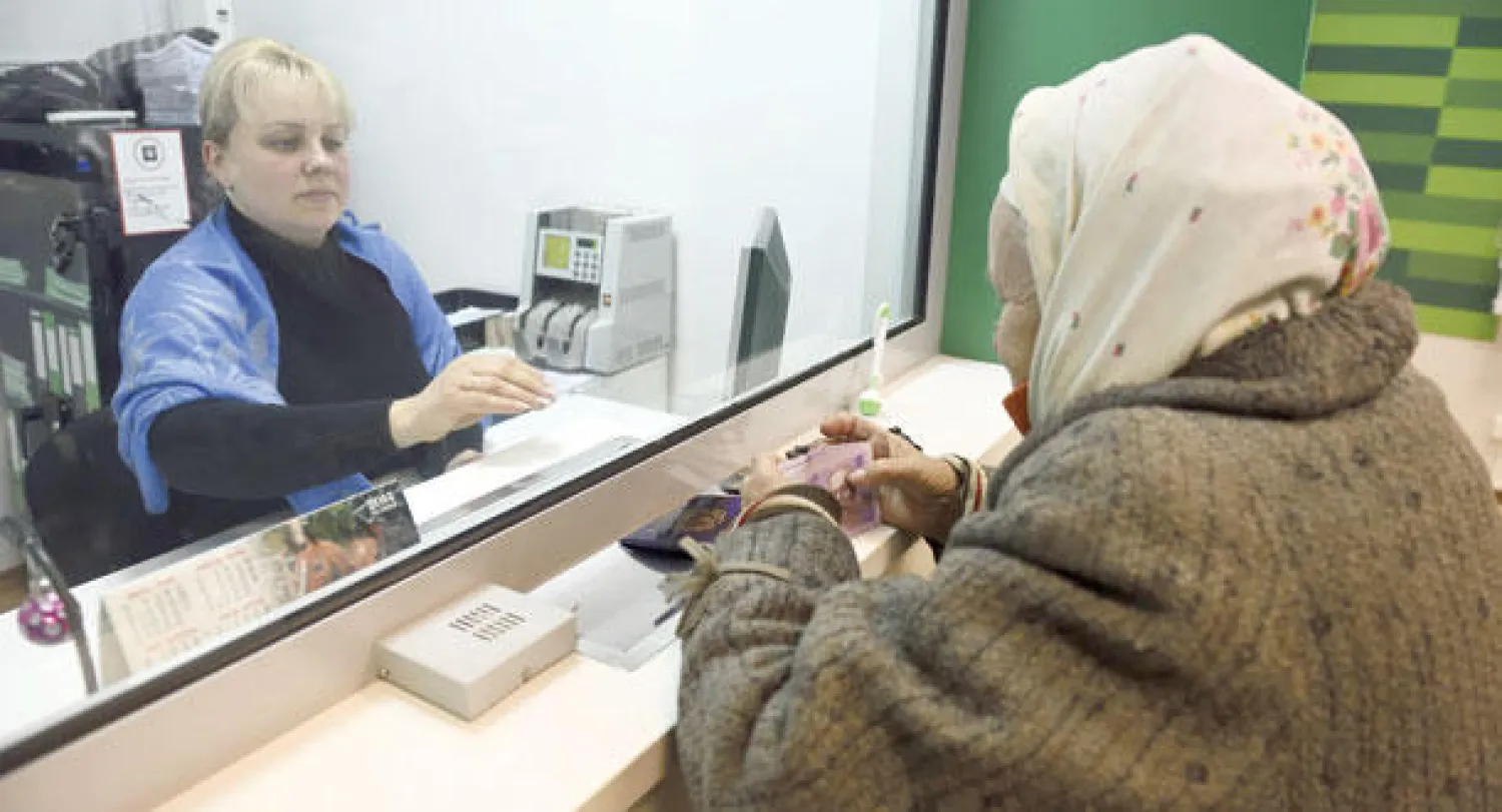 امرأة تتلقى مساعدات مالية في مدينة دونيتسك الخاضعة لسيطرة المتمردين في شرق أوكرانيا أمس (أ.ف.ب)