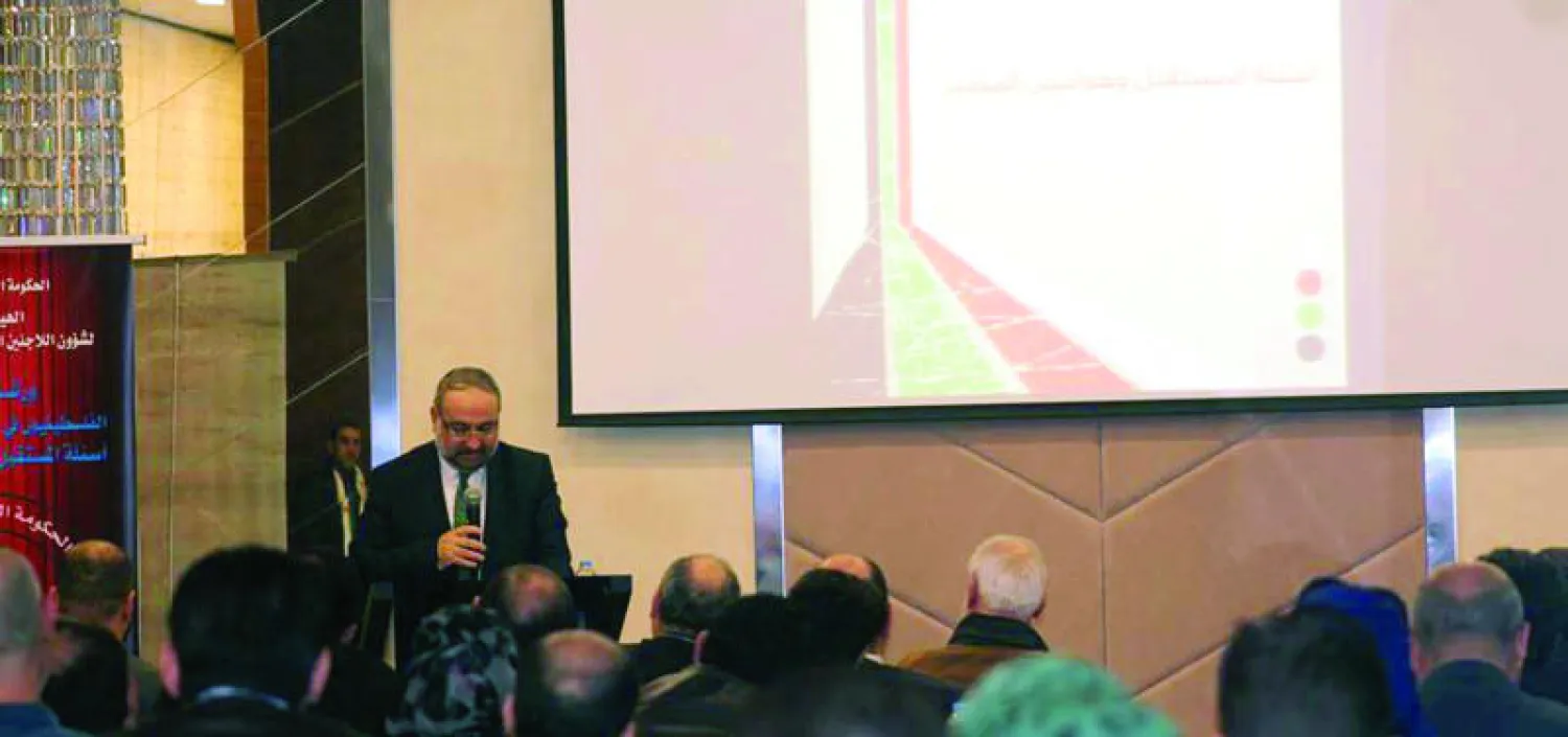 د.أحمد طعمة رئيس الحكومة السورية المؤقتة، يلقي كلمة بورشة عمل نظمتها «الهيئة العامة لشؤون اللاجئين الفلسطينيين في سوريا» («الشرق الأوسط»)