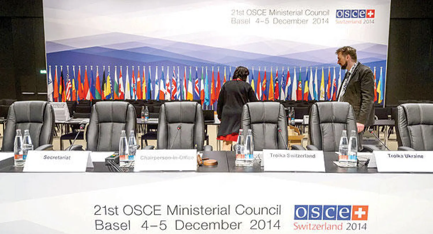 مساعدان يرتبان قاعة الاجتماعات أمس عشية اللقاء الوزاري لمنظمة الأمن والتعاون في أوروبا المرتقب عقده في مدينة بازل السويسرية اليوم (ا.ف.ب)